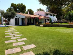 un jardín con un camino de piedra frente a una casa en Galdana's House en Cala Galdana