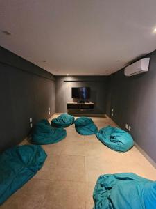 a room with three beds and a tv in it at Edifício Infinite in Ribeirão Preto