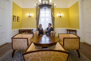 un homme et une femme assis à une table dans une salle à manger dans l'établissement Erzsébet Nagy Szálloda, à Paks