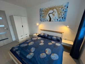 1 dormitorio con 1 cama con edredón azul en Apartmán u zámecké zahrady, en Klášterec nad Ohří