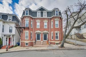 een groot rood bakstenen huis met een zwart dak bij Cozy Somerville Studio 2 Mi to Boston, Walk to T! in Somerville