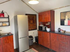 a kitchen with wooden cabinets and a refrigerator at Iris Retreat & Island Day Spa in Hartbeespoort