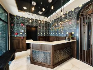 道尔顿The Carpentry Hotel的餐厅内有花卉墙的酒吧