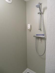 a shower in a bathroom with a shower head at Hotel Blooker in Renesse