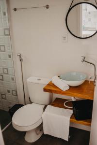 a bathroom with a toilet and a sink at Pousada Recanto das Cerejeiras in Rio Grande