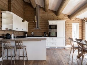 uma cozinha com armários brancos e paredes de madeira em Åre Valley Lodges - Björnbergshyllan 9B em Åre