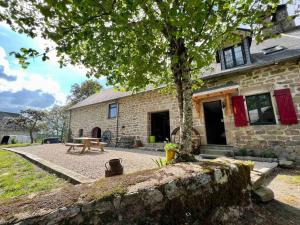 a stone house with a picnic table in front of it at Ferme pleine nature en Corrèze in Saint-Yrieix-le-Déjalat