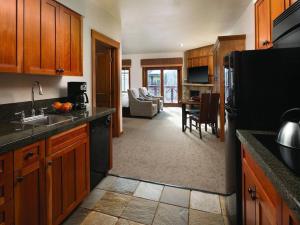 a kitchen with a black refrigerator and a living room at Hyatt Main Street Station Studio in Breckenridge