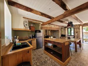 a large kitchen with wooden counters and a table at Ferme pleine nature en Corrèze in Saint-Yrieix-le-Déjalat