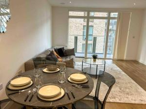 a dining room with a table and a couch at Stunning two bedroom apartment in London