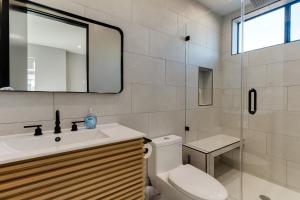 a bathroom with a toilet and a sink and a mirror at Brand New Modern 4 Bedroom House Pickfair Village in Los Angeles