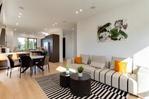 een woonkamer met een bank en een eetkamer bij Brand New Modern 4 Bedroom House Pickfair Village in Los Angeles
