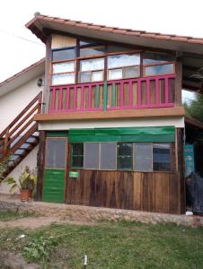 a house with a green door and a wooden fence at Los Aventureros in Samaipata