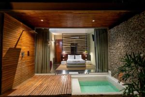 um quarto com uma cama e uma banheira num quarto em Cacaoni Hotel em Puerto Colombia