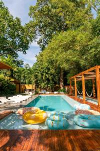 - une piscine avec des chaises longues et un bouquet de matelas gonflables dans l'établissement Cacaoni Hotel, à Puerto Colombia