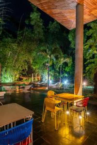 a patio with a table and chairs at night at Cacaoni Hotel in Puerto Colombia