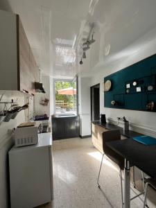 uma cozinha com paredes azuis e brancas e uma mesa em Villa bernadac em Ornolac-Ussat-les-Bains