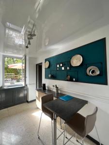 uma sala de jantar com uma mesa e uma parede azul em Villa bernadac em Ornolac-Ussat-les-Bains