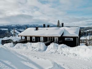 Cabaña cubierta de nieve en la cima de una montaña cubierta de nieve en Åre Valley Lodges - Björnbergshyllan 9B, en Åre