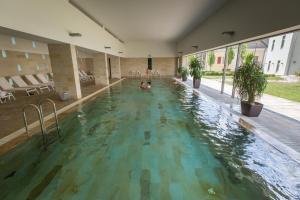 a person swimming in an indoor swimming pool at Erzsébet Nagy Szálloda in Paks
