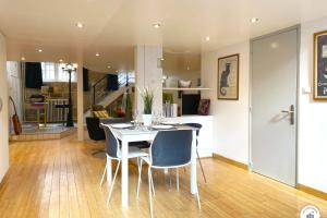 a dining room and living room with a table and chairs at Loft de l'Artiste - Parking - Standing in Rouen