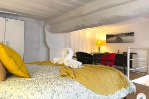 a bedroom with a bed with a yellow blanket at Loft de l'Artiste - Parking - Standing in Rouen
