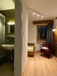 ein Badezimmer mit einem Waschbecken, einem Stuhl und einem Spiegel in der Unterkunft Appartements Dobler - s'Zischgn in Arzl im Pitztal