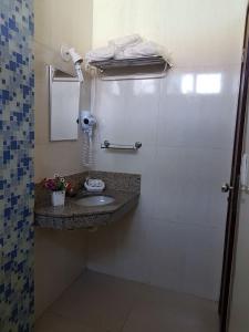 a bathroom with a sink and a shower at Hotel Minastur in Capitólio