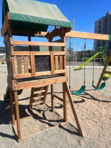 a wooden playground with a slide in a park at Departamento Peñuelas in Coquimbo