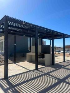 a metal pavilion with a bench under it at Departamento Peñuelas in Coquimbo