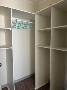 a walkin closet with white shelves and blue hangers at Departamento Peñuelas in Coquimbo