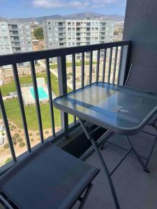 a blue table and bench on a balcony with a view at Departamento Peñuelas in Coquimbo