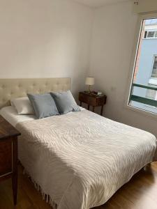 Schlafzimmer mit einem weißen Bett und einem Fenster in der Unterkunft PARIS 10 ' BASTILLE (CHARENTON LE PONT) in Charenton-le-Pont