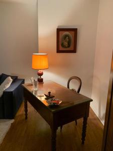 ein Wohnzimmer mit einem Tisch mit einer Lampe und einer Couch in der Unterkunft PARIS 10 ' BASTILLE (CHARENTON LE PONT) in Charenton-le-Pont