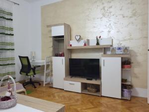 uma sala de estar com televisão num centro de entretenimento branco em Grand Apartman San with garage em Saraievo