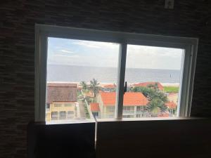 a window with a view of the ocean and buildings at Cocooning vue sur mer in Pointe-Noire