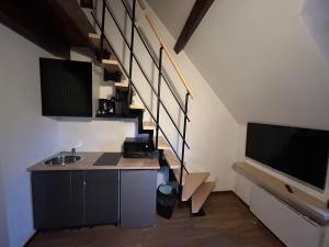 une cuisine avec un évier et un escalier avec une télévision dans l'établissement Reve Divin T4 avec parking-barbecue-laverie-bagagerie-salle de sport-aire de jeux-climatisé, à Lourdes 7 autres photos