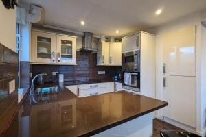 a kitchen with white cabinets and a brown counter top at Fantastic Central 2DB Apt in Hulme in Manchester