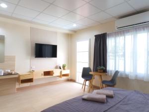 Schlafzimmer mit einem TV, einem Bett und einem Schreibtisch in der Unterkunft Studio 36 in Bangkok