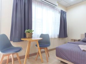 a bedroom with a table and two chairs and a bed at Studio 36 in Bangkok