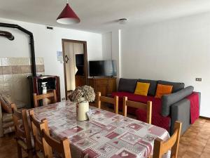 a living room with a table and a couch at Maison Moioli - Appartamento 3 in Piamprato