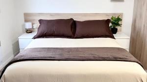 Ozoir-la-Ferrièreにある*Stud'Oz* Paris - Disneyland - Val d'Europeのベッドルーム1室(大型ベッド1台、ブラウンの枕付)