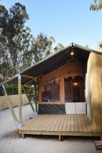 a small house with a black roof and a wooden porch at Parque Laguna de Zapallar in Maitencillo +78 photos
