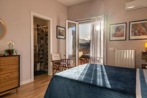 a bedroom with a bed with a blue bedspread at La Paperella Blu Apartment in Termini Imerese