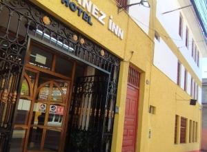 ein Geschäft vor einem Gebäude mit einer roten Tür in der Unterkunft Hotel Yañez Inn in Ayacucho