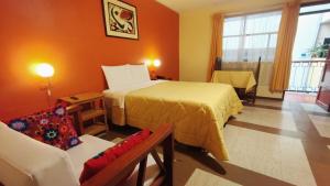 a hotel room with a bed and a chair at Hotel Yañez Inn in Ayacucho