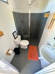 a small bathroom with a toilet and a sink at Vila Cajuzinho in Caraíva