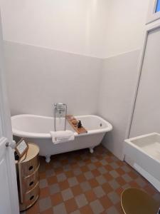 a white bathroom with a tub and a sink at Suite haussmannienne en Sologne in Vierzon