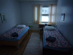 two beds in a small room with a window at saarnimaja in Hämeenlinna