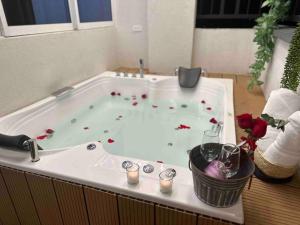 una bañera con flores rojas. en noah apartasuite 601, en Cali